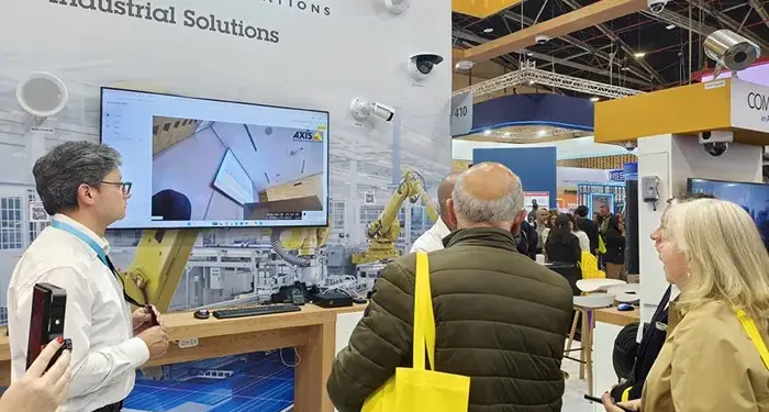 Visitantes observando una demostración de soluciones industriales en un stand de ferias comerciales.