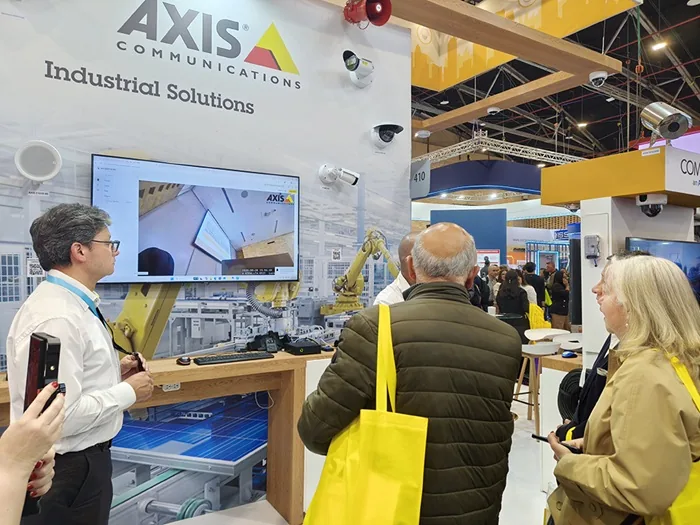 Visitantes observando una demostración de soluciones industriales en un stand de ferias comerciales.