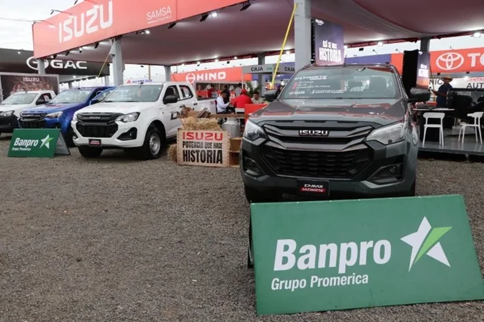 Exhibición de camionetas Isuzu en un evento comercial con carteles publicitarios de Banpro Grupo Promerica.