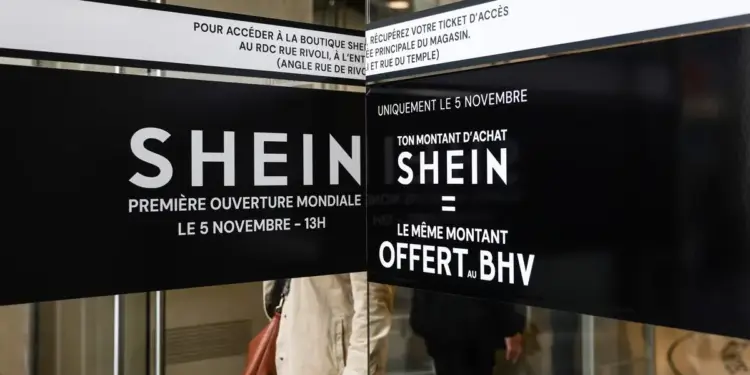 Carteles negros con letras blancas anuncian la apertura mundial de la tienda Shein el 5 de noviembre, con una promoción de compra igualada por BHV, en la entrada de un establecimiento.