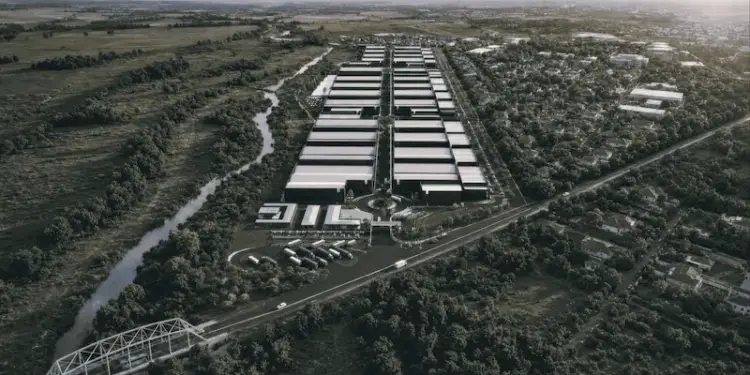 Vista aérea de un gran complejo industrial y logístico con múltiples naves y camiones de carga.