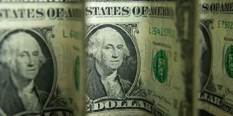 Primer plano de varios billetes de un dólar estadounidense, mostrando el retrato de George Washington y el texto 'STATES OF AMERICA' y 'ONE DOLLAR'.