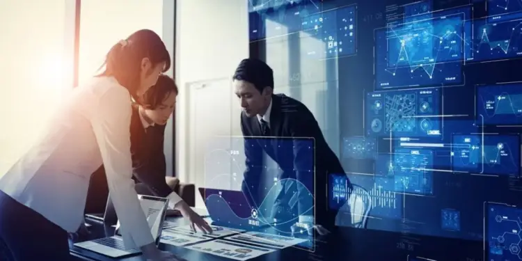 Tres profesionales analizando gráficos digitales y datos financieros sobre una mesa de reuniones.