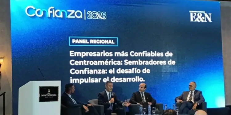 Cuatro empresarios en un panel de discusión sobre confianza y desarrollo en Centroamérica, con una pantalla mostrando 'Confianza 2026' y el tema del evento.