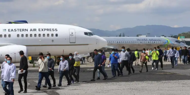 Grupo de personas caminando en la pista de un aeropuerto frente a aviones de Eastern Air Express y World Atlantic.