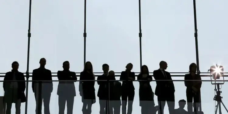 Siluetas de un grupo de personas de negocios frente a un gran ventanal
