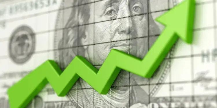 Una flecha verde 3D ascendente sobre un billete de cien dólares estadounidenses y un gráfico de cuadrícula, simbolizando crecimiento financiero y económico.