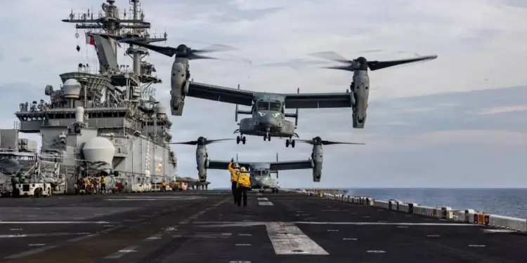Dos aeronaves de despegue vertical operando en la cubierta de un gran buque militar en el mar.