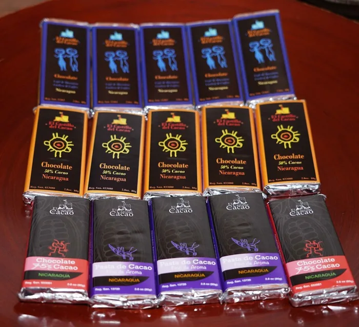 Varias barras de chocolate 'El Castillo del Cacao' de Nicaragua, con 50% y 75% cacao, y pasta de cacao, en empaques coloridos.