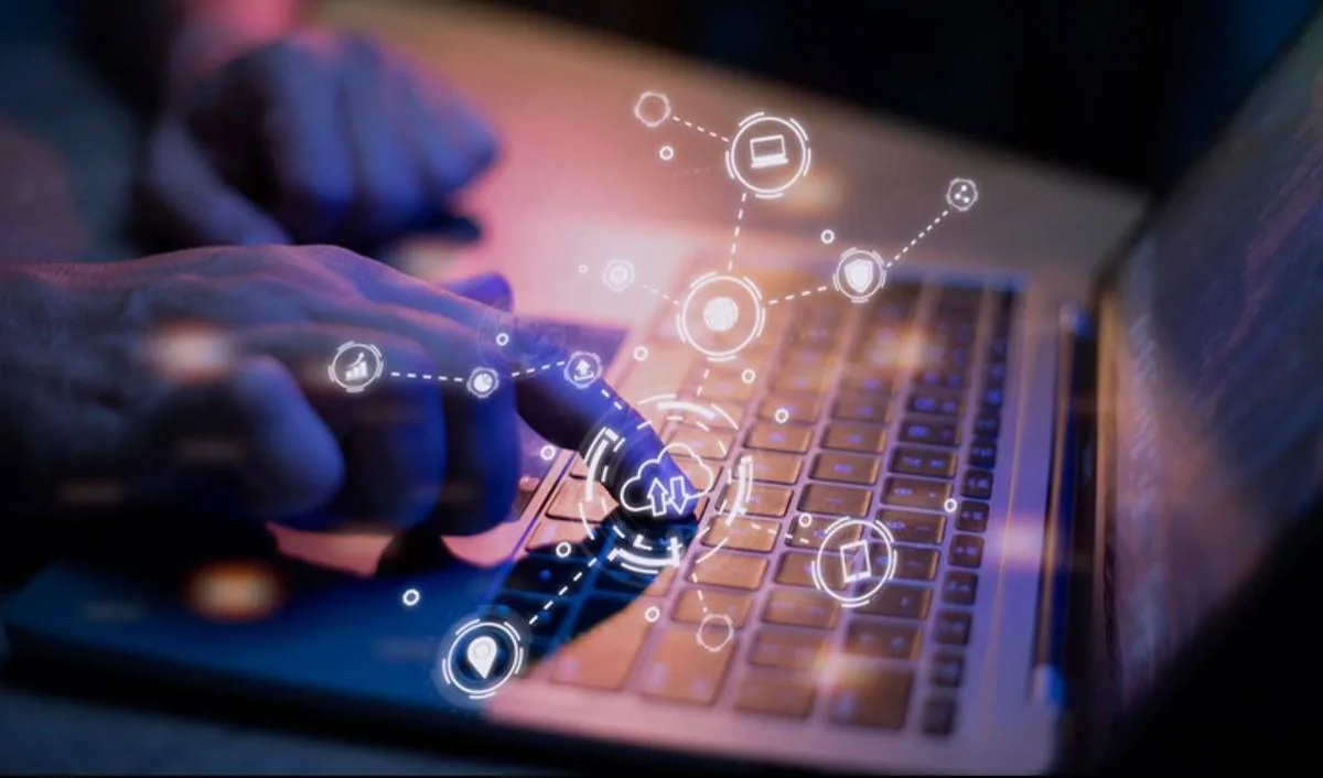 Manos sobre un teclado de laptop con una superposición de iconos digitales interconectados, representando tecnología, datos, seguridad y computación en la nube. Fondo oscuro.