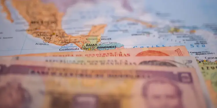 Billetes de Lempiras hondureños sobre un mapa de Centroamérica, destacando Honduras, Guatemala y México. Enfoque en economía regional.