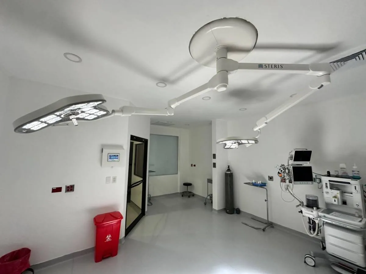 Quirófano moderno y bien iluminado con luces quirúrgicas STERIS, equipo médico avanzado, monitores y un tanque de oxígeno. Refleja inversión en infraestructura hospitalaria.
