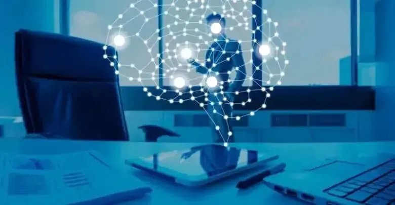 Representación de inteligencia artificial con un cerebro digital sobre un profesional en una oficina. En primer plano, una tablet, documentos con gráficos y un teclado de laptop.