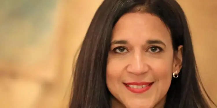 Primer plano de una mujer profesional sonriendo con cabello oscuro y blusa negra
