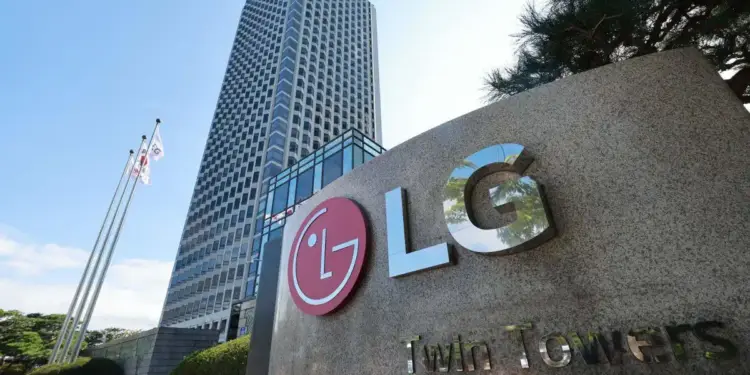 Vista exterior de la sede corporativa de LG con su logo en un cartel de piedra, un rascacielos moderno y banderas ondeando bajo un cielo azul.