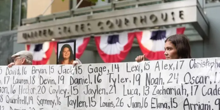 Manifestantes con pancarta de nombres y edades frente a un edificio que dice 'United States Courthouse', decorado con banderines patrióticos. Una mujer sostiene una foto.