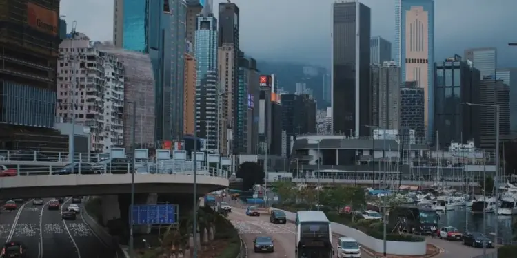 Vista panorámica de un distrito financiero urbano con rascacielos modernos, autopistas elevadas y tráfico vehicular.