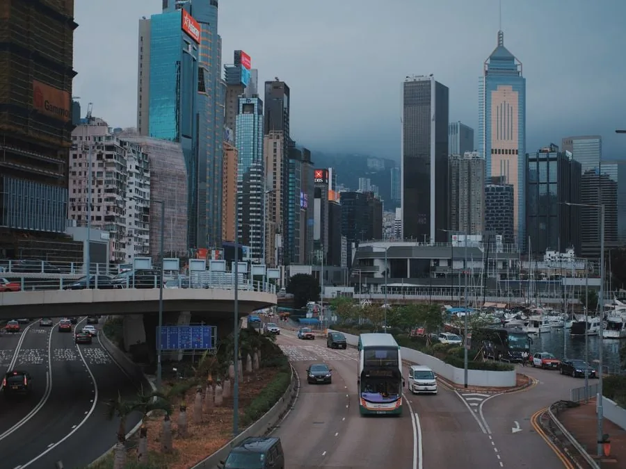 Vista panorámica de un distrito financiero urbano con rascacielos modernos, autopistas elevadas y tráfico vehicular.