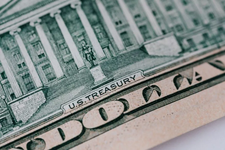 Primer plano de un billete de dólar con la inscripción US Treasury y detalles arquitectónicos grabados.
