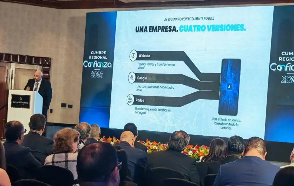 Hombre en traje presenta en podio con logo Intercontinental. Pantalla gigante exhibe 'Cumbre Regional Confianza 2026' y diagrama de empresa digital con AI.