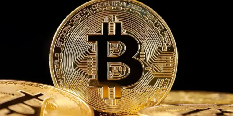 Primer plano de una moneda física dorada de Bitcoin con circuitos grabados sobre un fondo oscuro.