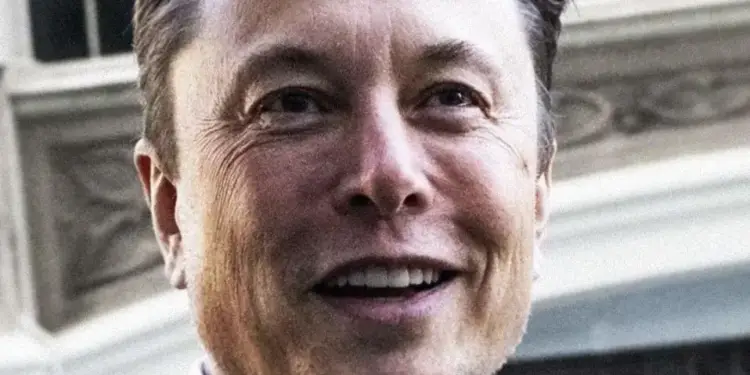 Primer plano de un empresario sonriente, de mediana edad, con traje oscuro y corbata, sobre un fondo arquitectónico borroso.
