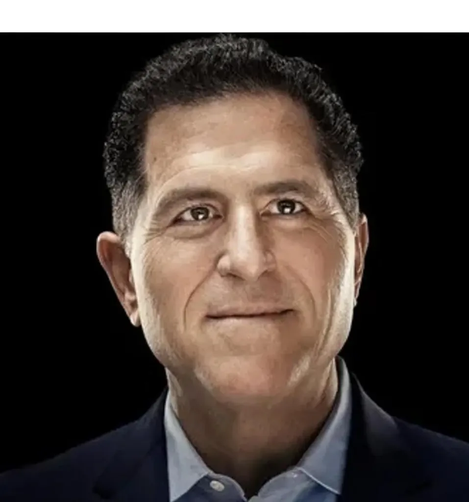 Primer plano de un hombre de mediana edad, tez clara, cabello oscuro y traje azul, con una expresión sonriente y profesional sobre fondo negro.