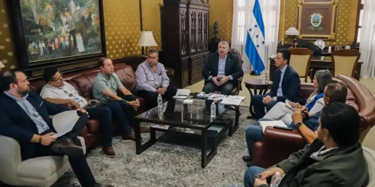 Grupo de profesionales en una reunión de negocios sentados alrededor de una mesa de centro en una elegante oficina.