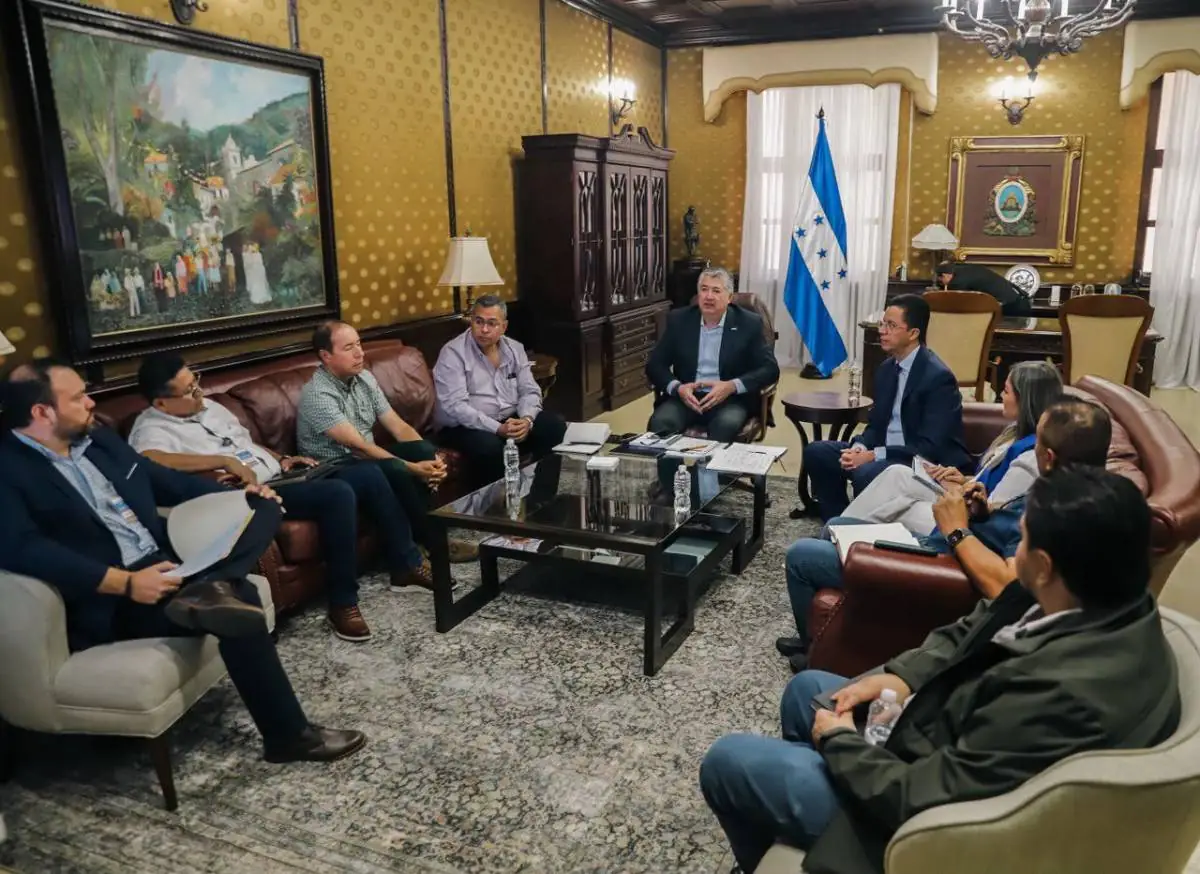 Grupo de profesionales en una reunión de negocios sentados alrededor de una mesa de centro en una elegante oficina.