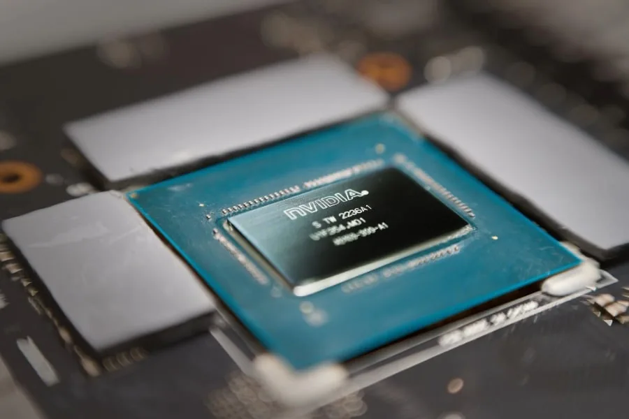 Primer plano de un microchip NVIDIA instalado en una placa base electrónica con componentes de hardware.