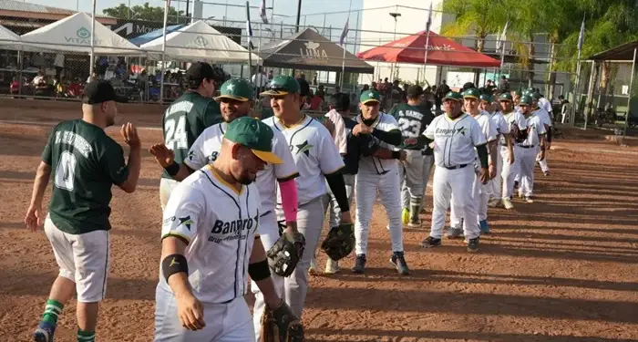 Jugadores de béisbol con uniformes deportivos saludándose en fila sobre el terreno de juego.