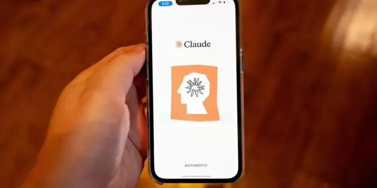 Mano sosteniendo un teléfono inteligente que muestra la aplicación Claude en la pantalla.