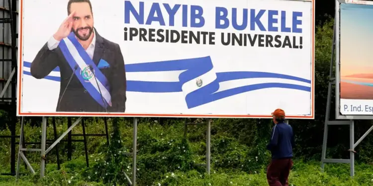 Gran valla publicitaria con Nayib Bukele en traje y banda presidencial, saludando. Texto: '¡PRESIDENTE UNIVERSAL!'. Persona camina.