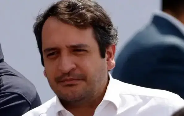 Primer plano de un hombre de negocios con camisa blanca en un evento profesional.