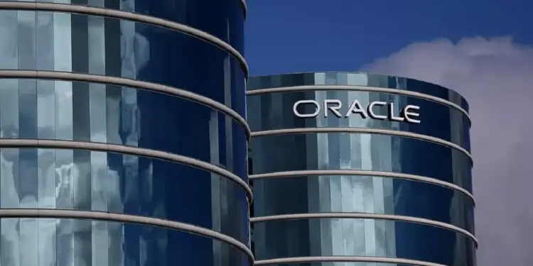Fachada de vidrio de dos torres corporativas circulares con el letrero de Oracle bajo un cielo azul.
