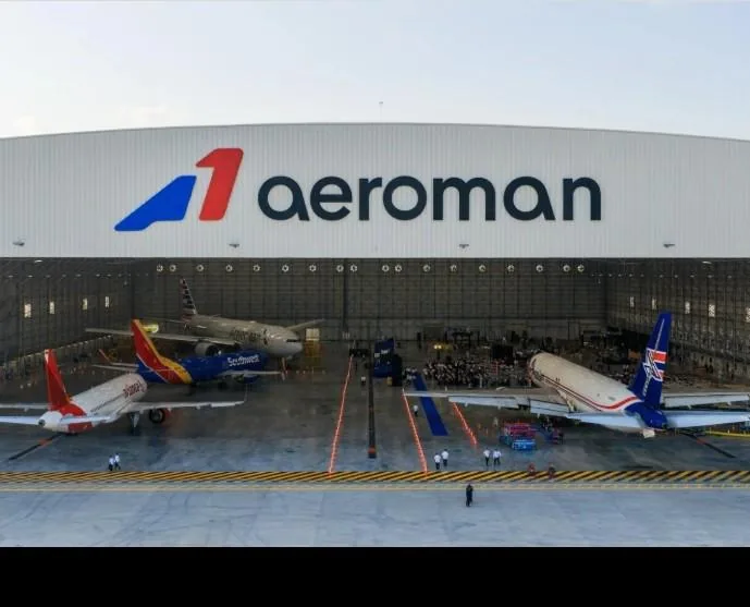 Vista exterior del gran hangar aeroman con múltiples aviones comerciales estacionados para mantenimiento.