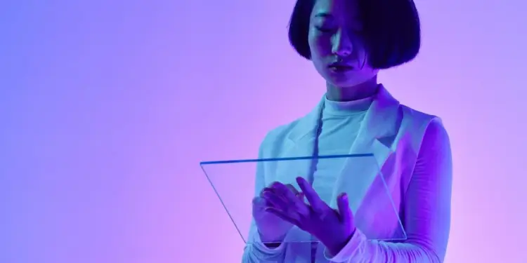 Mujer con cabello oscuro interactuando con una pantalla transparente futurista. Viste ropa profesional y está inmersa en un entorno de luz neón púrpura y azul, simbolizando innovación tecnológica en finanzas.
