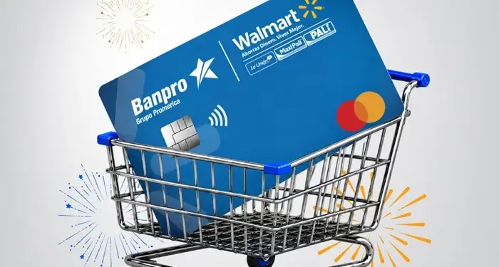 Tarjeta de crédito azul de Banpro y Walmart dentro de un carrito de compras metálico con fuegos artificiales de fondo.