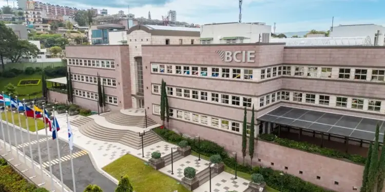 Vista exterior del moderno edificio corporativo del BCIE rodeado de áreas verdes y banderas