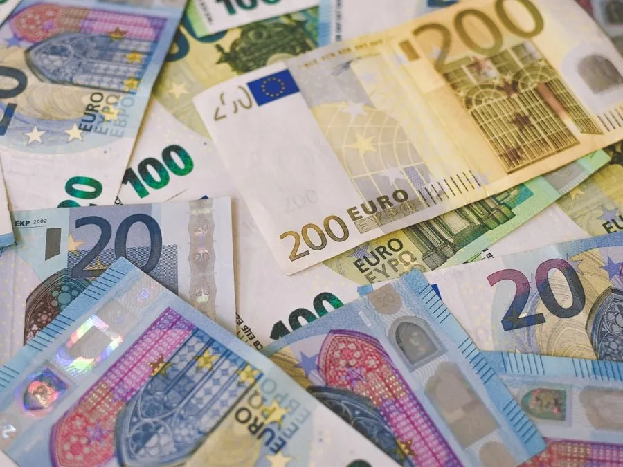 Primer plano de varios billetes de euro en efectivo de diferentes denominaciones dispuestos desordenadamente.