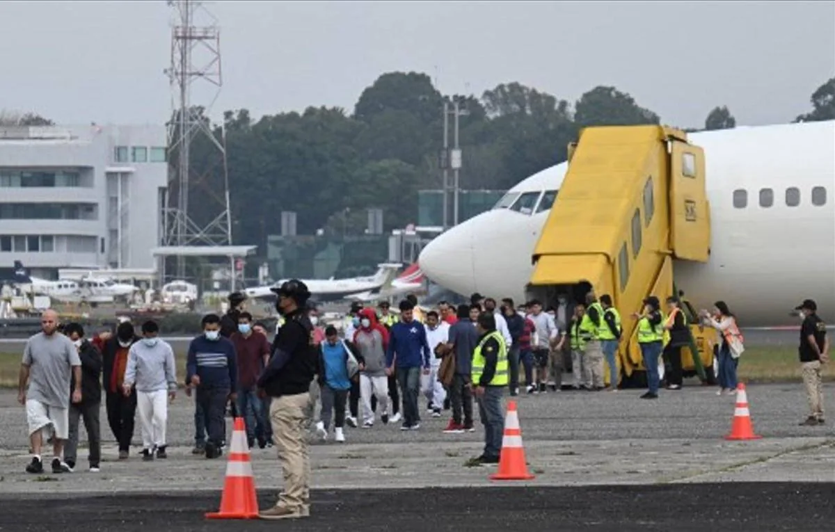 Grupo de personas caminando por la pista de un aeropuerto cerca de un avión comercial con una escalera amarilla.