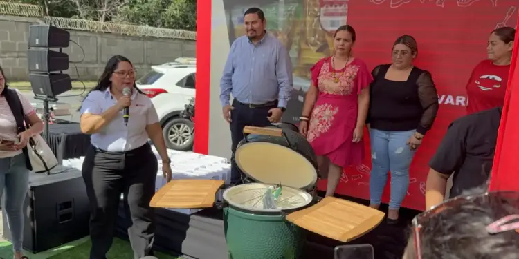 Parrilla Big Green Egg tamaño L abierta sobre la tarima de Distrito Carnic, frente a ganadoras de la promoción Comprá y Ganá