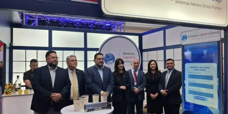 Grupo de profesionales de pie en un stand de la feria comercial America Logistics Group con una pantalla digital interactiva.