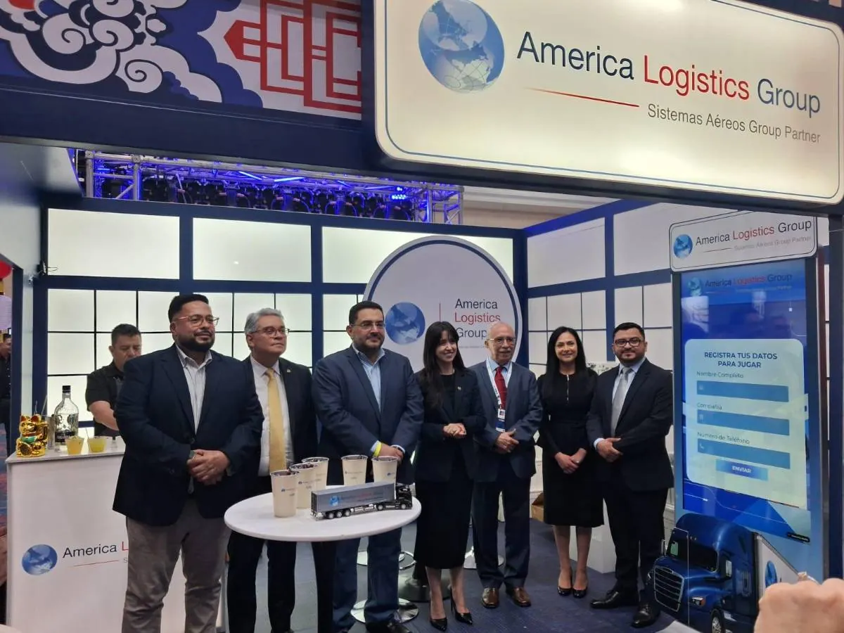 Grupo de profesionales de pie en un stand de la feria comercial America Logistics Group con una pantalla digital interactiva.