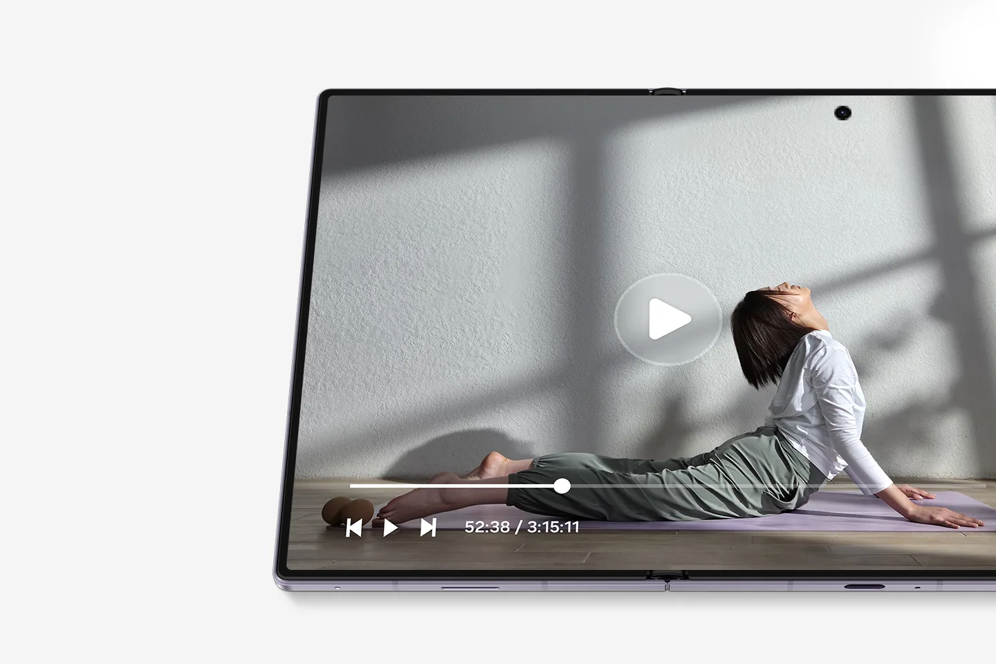 Primer plano de una pantalla que reproduce un video de una persona practicando yoga en una esterilla.