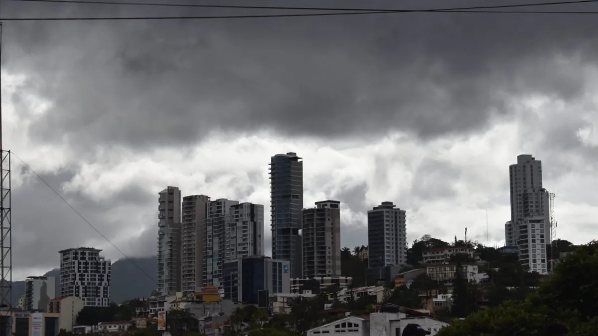 Vista de varios edificios modernos de oficinas bajo un cielo nublado y tormentoso en un distrito financiero.