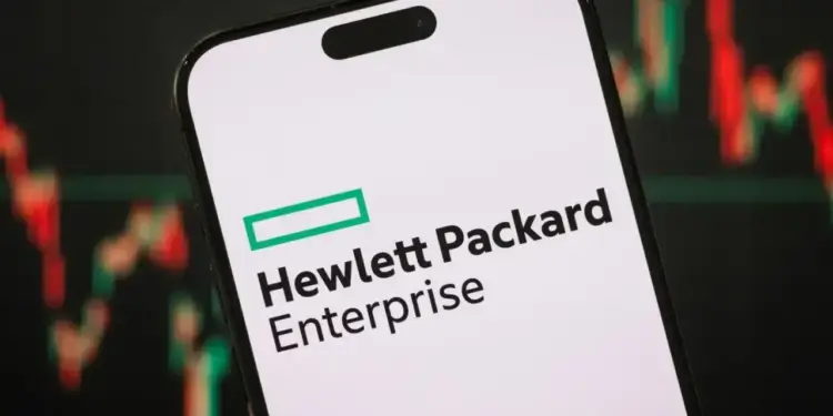 Logotipo de Hewlett Packard Enterprise en la pantalla de un smartphone con gráficos bursátiles al fondo.