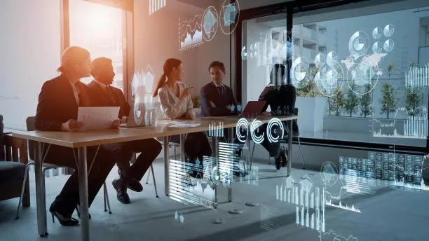 Grupo de profesionales en reunión ejecutiva con gráficos e indicadores financieros digitales superpuestos.