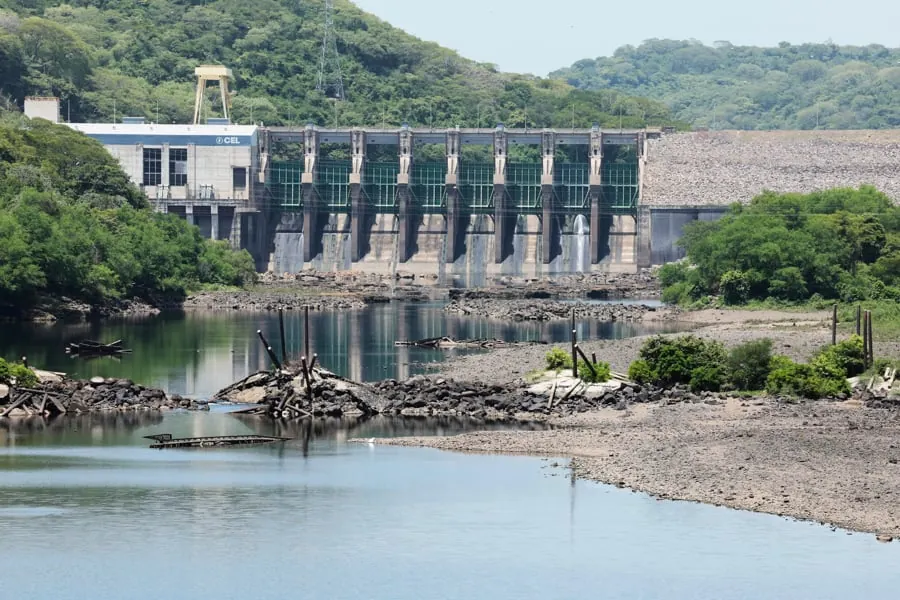 Vista panorámica de una presa hidroeléctrica con un río y vegetación en los alrededores.