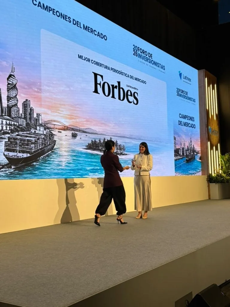 Dos mujeres presentan un premio de Forbes Centroamérica en el Foro de Inversionistas en Panamá.
